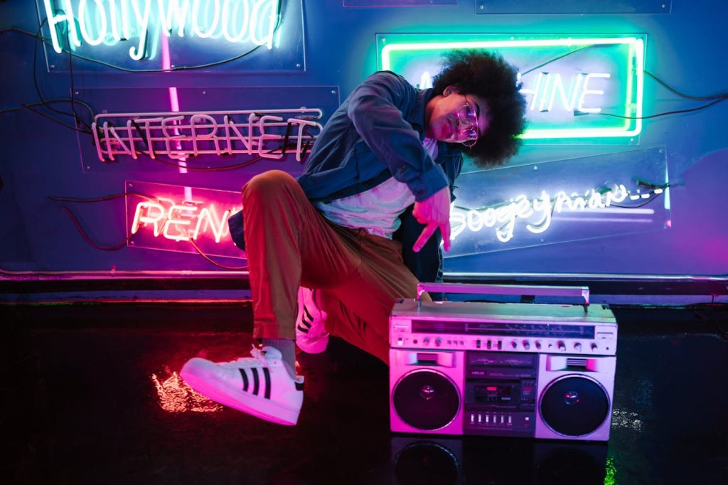 Stylish man poses with a retro boombox in a vibrant neon-lit club scene, evoking a cool nightlife vibe.