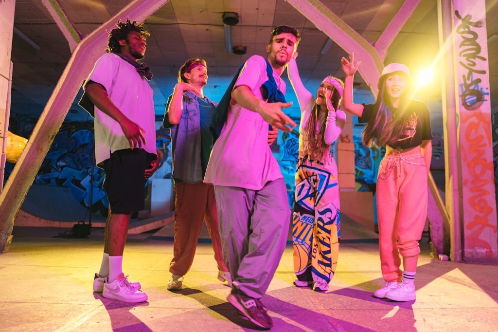 Energetic friends dancing under neon lights in an urban graffiti-filled skate park.